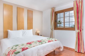 Bright and welcoming bedroom with cheerful floral accents, offering a peaceful retreat.