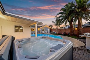 Soak under the stars in the private hot tub or unwind poolside surrounded by swaying palms — your backyard oasis awaits.