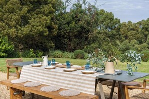 Outside in the courtyard, entertain with family surrounded by the lush National Trust bushland