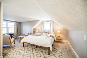 The upstairs bedroom is a serene retreat with a queen-size bed, luxurious sheets, a cozy duvet, and an ultra-comfy mattress. Enjoy curling up with a book in the seating area or unwinding for a restful night’s sleep—comfort is the priority here!