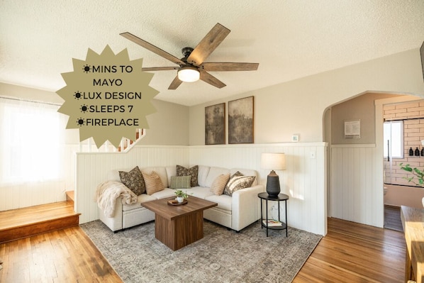 Step into this bright living space, where a cozy sleeper sectional invites relaxation. Stream your favorite shows on the smart TV, while large windows flood the room with natural light, creating a warm and welcoming ambiance.