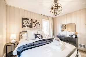 Chic Black and White Retreat
Unwind in this stylish black-and-white-themed bedroom, complete with a plush queen bed, elegant décor, and a unique fandelier for a touch of modern charm.
