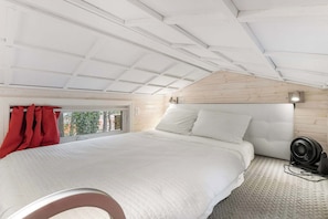 Experience a cozy loft retreat with a charming sloped ceiling and inviting views. Perfect for a peaceful getaway!