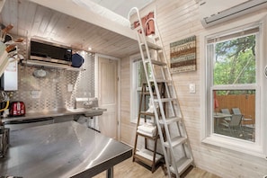 Charming kitchen with modern amenities and a cozy lofted bed, perfect for a relaxing getaway!