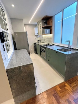 The kitchen is integrated with the laundry room. Kitchen with filtered water, pots & pans, dinnerware, silverware, and coffee maker.