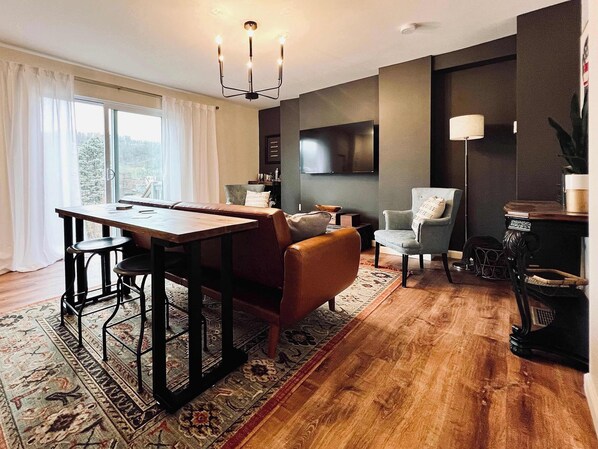LIVING ROOM | FIRST FLOOR: Relax with your fellow travelers in our designer living room. A sofa, armchairs, and a table with bar stools accommodate any seating preference. Watch your favorite shows & movies on the Smart TV while you unwind!