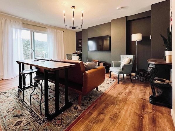 LIVING ROOM | FIRST FLOOR: Relax with your fellow travelers in our designer living room. A sofa, armchairs, and a table with bar stools accommodate any seating preference. Watch your favorite shows & movies on the Smart TV while you unwind!