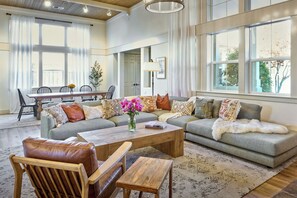 Oversized great room with vaulted ceilings, fireplace, Sonos, and 75" TV.