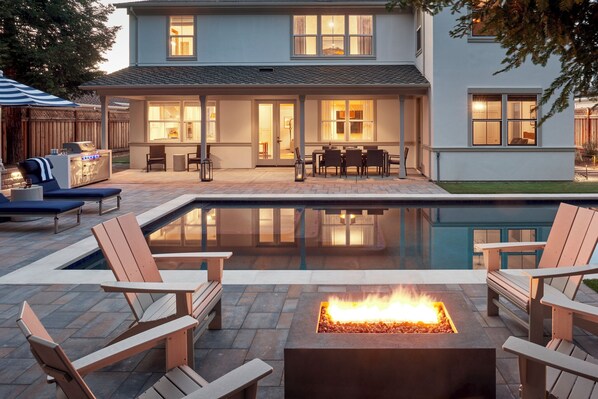 Backyard oasis: heated pool, spa, outdoor shower, BBQ, corn hole & fire pit.