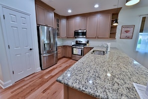 Chef-inspired kitchen features stainless steel appliances, dishwasher, disposal, refrigerator withthrough-the-door ice maker and water, natural gas stove, and coffee maker.