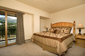 The master bedroom features a queen bed and access to the private balcony