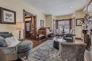 Main living room: Spacious living room makes for a great gathering area - play the piano, drink coffee by the window or warm up by the fire!