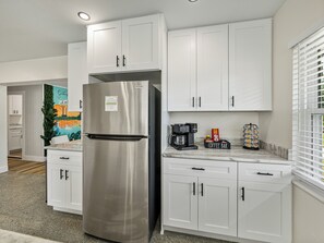 This stylish coffee bar features a dual Keurig system for drip coffee and single-serve cups, offering both hot and cold beverage options. Sleek storage keeps Keurig cups, creamers, and sweeteners organized, blending style and functionality for your coffee breaks.