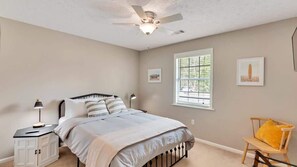 Guest bedroom with smart TV and phone charging stations 
