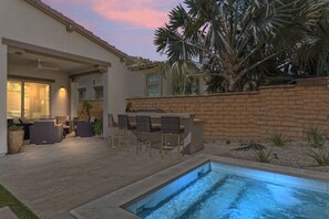 Relax in the private spa and outdoor bar area under the sunset sky.