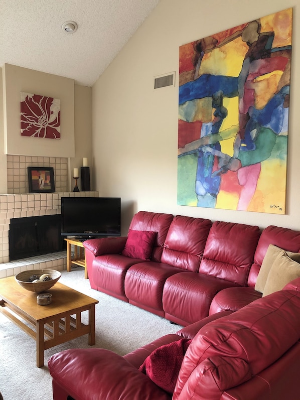 Living room is comfortable & bright with high vaulted ceiling and inspiring art.