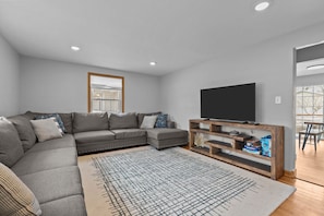 Living room with a Smart TV and a stack of board games for endless fun!