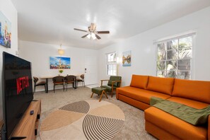 Living Room with 65" television, sofa sleeper, armchair with footrest