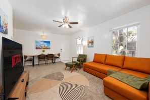 Living Room with 65" television, sofa sleeper, armchair with footrest