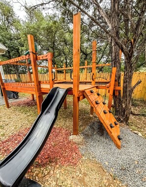 Large treehouse with climbing wall, slide and oversized hammock.