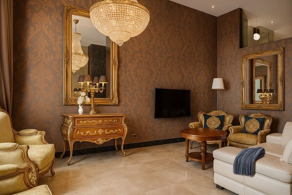 Chic living area featuring ornate gold décor, large mirrors, and plush seating in an open-plan design