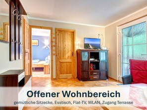 Offener Wohnbereich mit gemütlichen Sitzmöbeln und Flat-TV.
