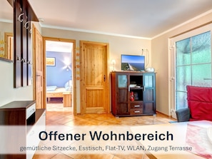Offener Wohnbereich mit gemütlichen Sitzmöbeln und Flat-TV.