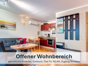 Offener Wohnbereich mit gemütlichen Sitzmöbeln und Flat-TV.