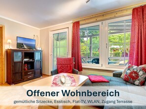 Offener Wohnbereich mit gemütlichen Sitzmöbeln und Flat-TV.