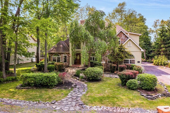 Step into your own fairytale at this enchanting stone-front escape, tucked among the trees with beautifully landscaped paths and cottage-style charm. From the moment you arrive, this home exudes warmth, character, and a sense of peaceful seclusion—perfect for your next unforgettable getaway.