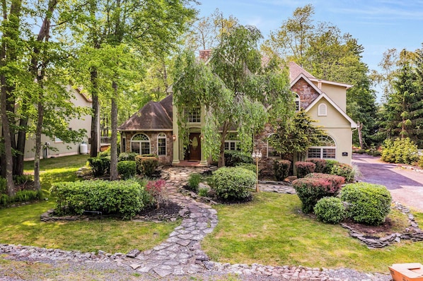 Step into your own fairytale at this enchanting stone-front escape, tucked among the trees with beautifully landscaped paths and cottage-style charm. From the moment you arrive, this home exudes warmth, character, and a sense of peaceful seclusion—perfect for your next unforgettable getaway.