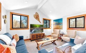 Comfortable family room with plush seating and large windows.