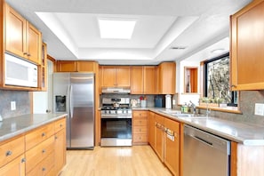 Fully equipped kitchen with stainless appliances and ample counter space.