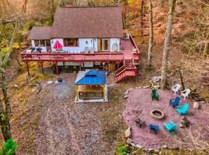 Front of property including covered hot tub and fire pit