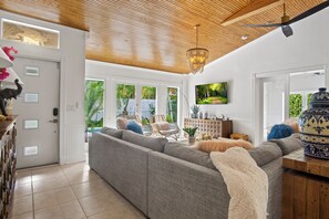 Large living area with doors that open to the deck and pool