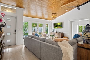Large living area with doors that open to the deck and pool