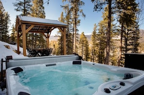 Oversized 6 person Hot Tub with massage jets and a lounge seat. On the patio with grilling and outdoor dining in the Gazebo.