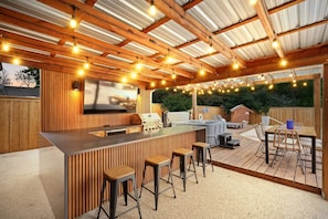 The indoor/outdoor lifestyle doesn’t get better than this! This outdoor bar comes fully decked out with a BBQ grill, outdoor TV, mini fridge, and bar-stool seating!
