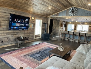 Treehouse in the Bay: Sleeps 10. The living room features a cozy gas fireplace and a smart TV for your entertainment. We also provide books, playing cards, and board games for a relaxing stay. Is there anything else that would make your visit even better?