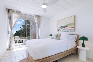 Recharge in the primary bedroom with a queen bed dressed in crisp linens and a ceiling fan overhead for extra breezes.