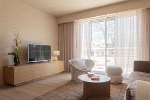 Stylish living room with comfortable seating and a large TV, ideal for unwinding with family or friends.