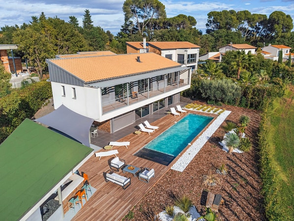 Aerial view of Villa Horizon showcasing the private pool, sun loungers, and lush Mediterranean garden nestled along the golf course.