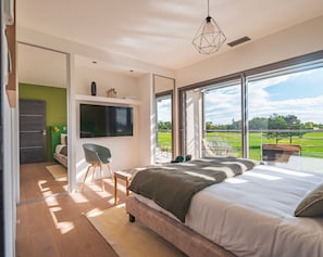 Serene bedroom retreat with direct outdoor access and abundant natural light, offering peaceful mornings in nature.