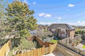 Peaceful garden area with patio furniture and potted plants, ideal for morning coffee or evening drinks