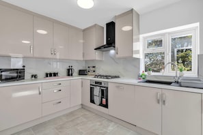 Fully equipped kitchen with modern appliances including a washer, dishwasher, and sleek cabinetry