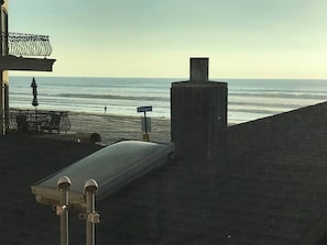 Portion of sand and ocean views from inside kitchen/living room over roof.