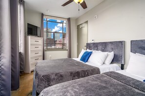Stylish bedroom with two queen beds, fresh linens, and a peaceful ambiance.