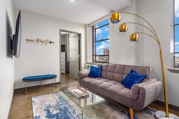 Stylish living area with bold decor, large windows, and a welcoming seating arrangement.