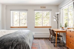 Sleek hotel room with ergonomic desk, fast Wi-Fi, smart TV, cozy bed, mood lighting, and a coffee/tea—ideal for productivity and relaxation.