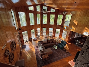 Great room with floor to ceiling window and warm knotty pine